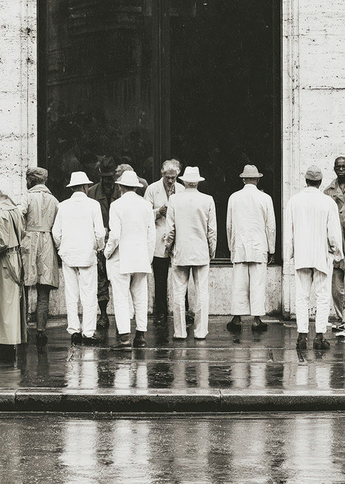 Black and white photo of men from the back in rain